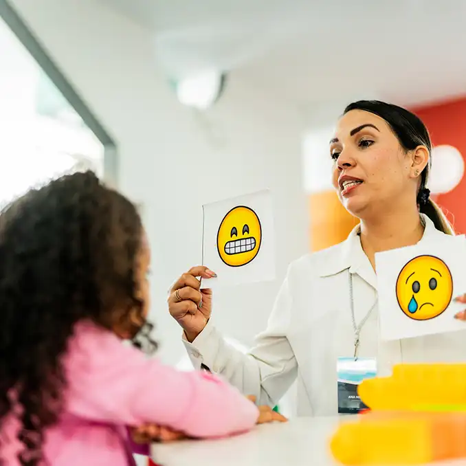 Adult using visual cue cards to communicate with child